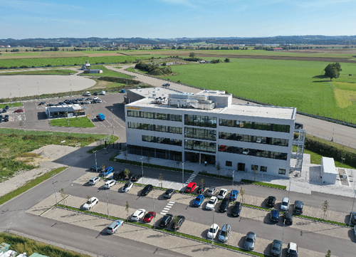 Das Gebäude des neuen Entwicklungscampus für Fahrassistenzsysteme und autonomes Fahren von Continental aus der Vogelperspektive. Hinter dem Gebäude ist die Teststrecke zu sehen.