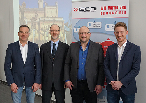 Gruppenfoto des ECN-Vorstands vor einem Roll-Up mit der Aufschrift: "ECN: Wir vernetzen Ergonomie": Wolfgang Schneider, MBA, Verwaltung ECN, Dr.- Ing. Frank Gillmeister, 1. Vorstand, Prof. Dr.- Ing. Karsten Kluth, 2. Vorsitzender, Darwin Abele, MSc., Schriftführer
